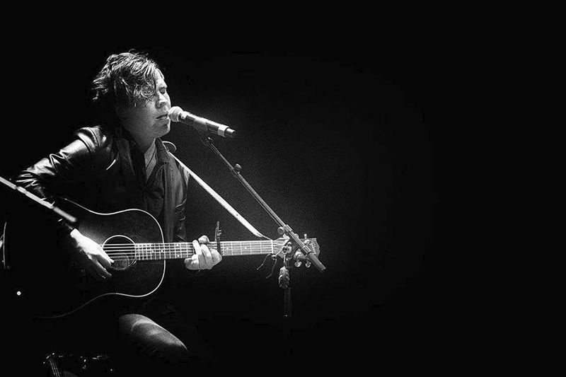 Mustavalkoisessa kuvassa esiintyy Tommi Kalenius kitaransa kanssa.