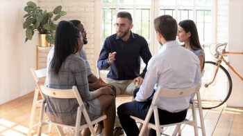 Ryhmä aikuisia pöydän ääressä.