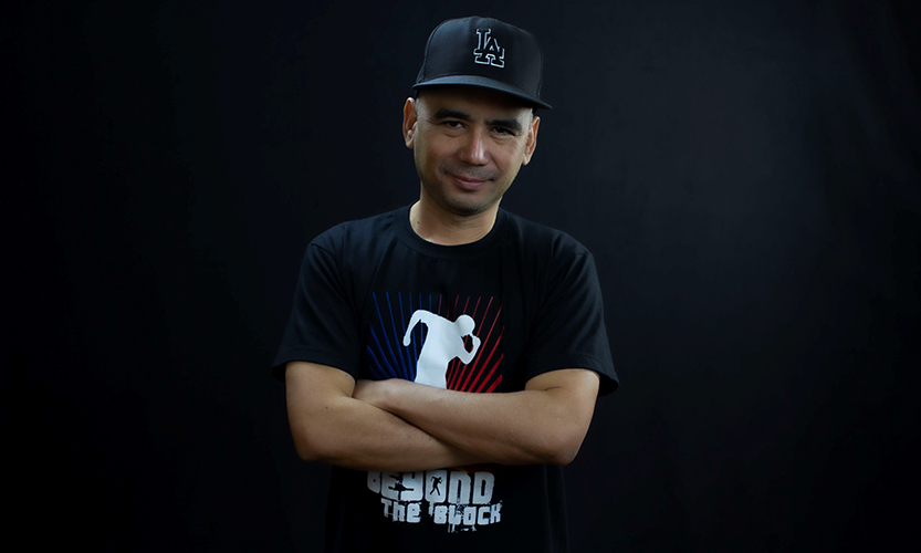 Kuvassa tanssinopettaja Ricky. Hän katsoo suoraan kameraan. Päässä on musta lippis.