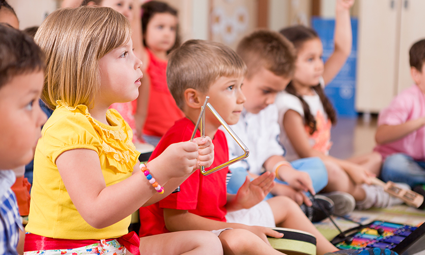 Kuvasssa leikki-ikäisiä lapsia soittamassa rytmisoittimia yhdessä.