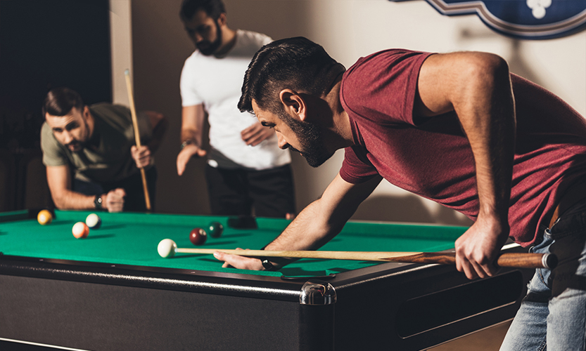 Kuvassa kolme henkilöä pelaa biljardia.