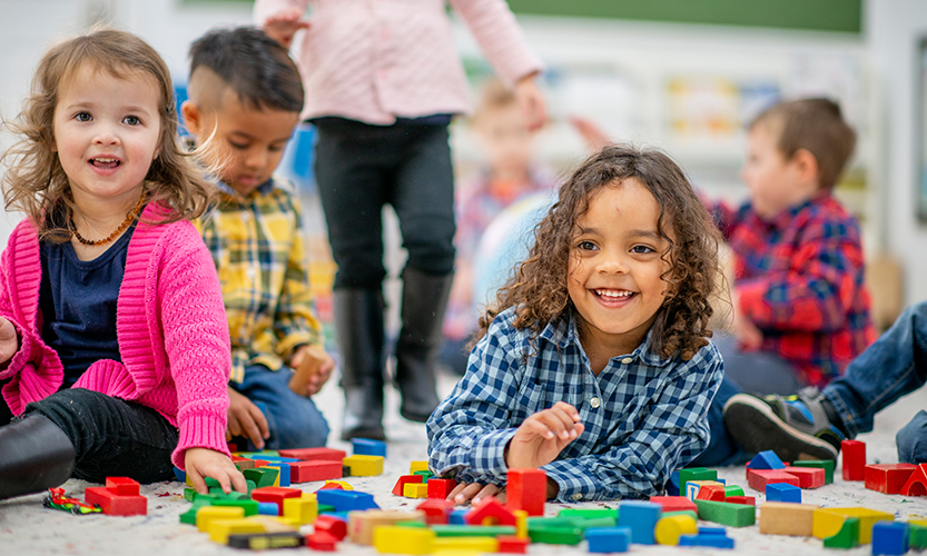 Kuvassa on iloisia leikkiviä lapsia.